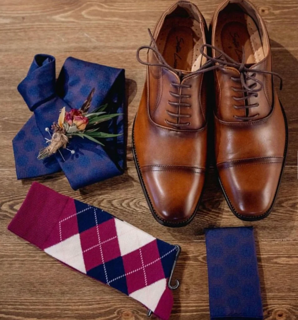 Brown Leather Oxford Dress Shoes Paired With Navy Tie, Burgundy Argyle Socks, And Blue Pocket Square For Cocktail Attire In Phoenix