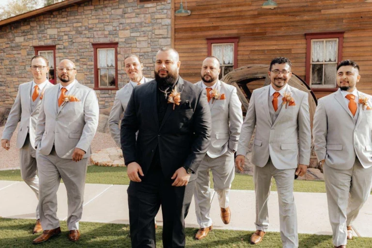 Groom and groomsmen wearing beige summer wedding suits for an outdoor ceremony.