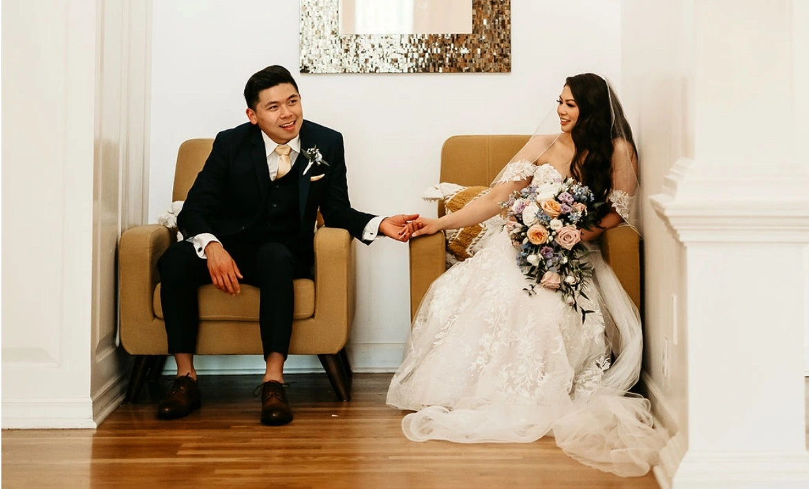 Elegant wedding couple holding hands indoors – Van Allan’s Men’s Fashion Phoenix
