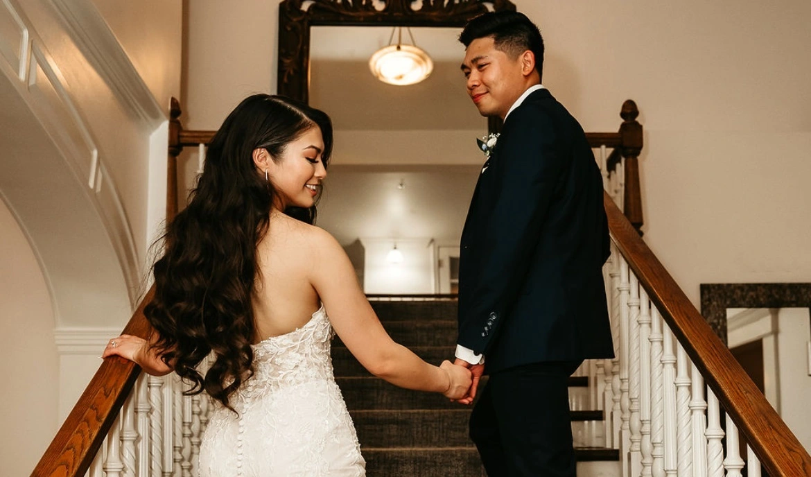 Bride and groom on staircase, groom in navy tuxedo – Van Allan’s Men’s Fashion Phoenix