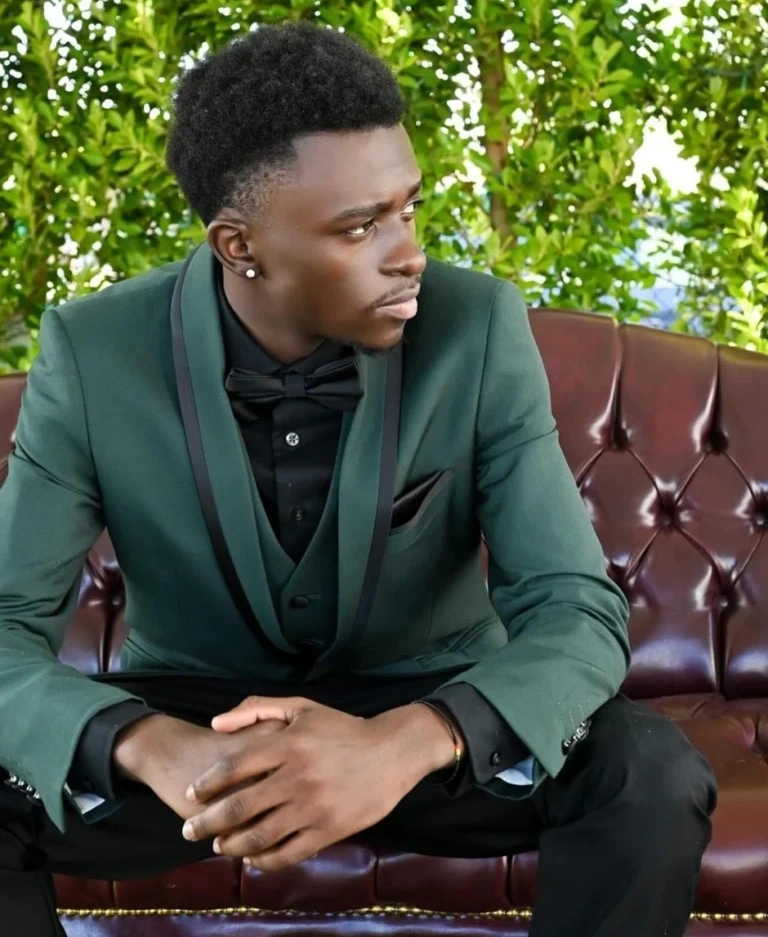 A Student Sitting In A Tailored Forest Green Three-Piece Prom Suit With Black Lapels, Demonstrating The 2026 Trend For Distinctive Yet Controlled Colors In Phoenix.