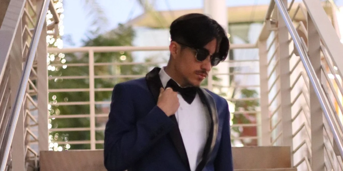 Man wearing a navy blue suit with bow tie at an outdoor Phoenix venue, perfect for semi-formal wedding attire.
